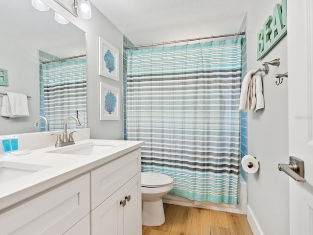 full bathroom with wood-type flooring, vanity, toilet, and shower / tub combo with curtain