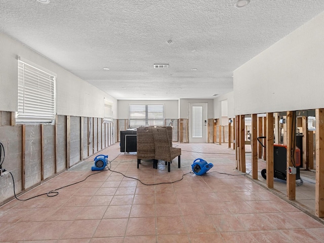 interior space featuring light tile patterned floors and a textured ceiling