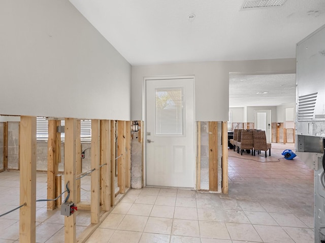 foyer featuring light tile patterned floors and a textured ceiling