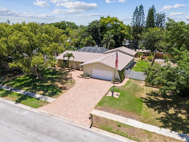 view of front of property with a front yard, a garage, and a lanai