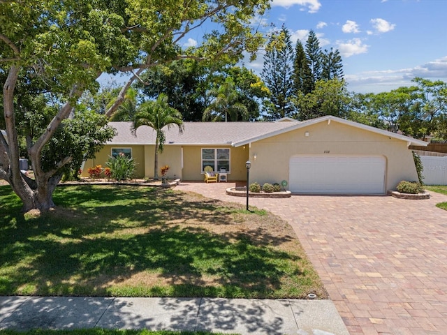 ranch-style home featuring a garage and a front lawn