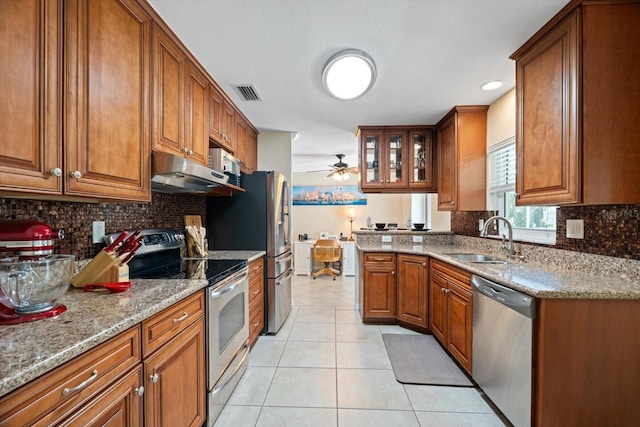 kitchen featuring visible vents, appliances with stainless steel finishes, glass insert cabinets, a sink, and under cabinet range hood