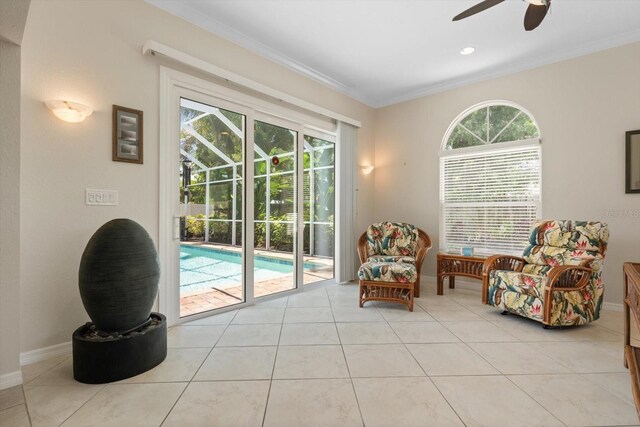 living area with a ceiling fan, crown molding, baseboards, and light tile patterned floors