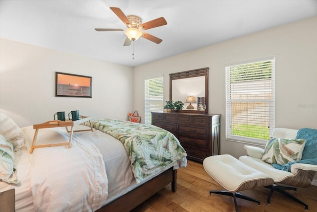 bedroom with light wood-style flooring, multiple windows, and ceiling fan