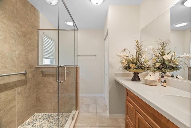 full bath featuring a shower stall, vanity, baseboards, and tile patterned floors