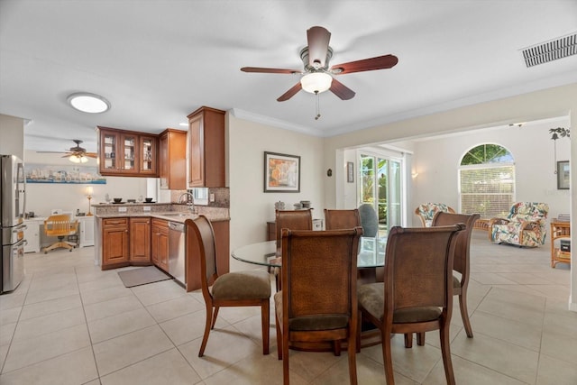 dining area featuring light tile patterned floors, ceiling fan, visible vents, and ornamental molding