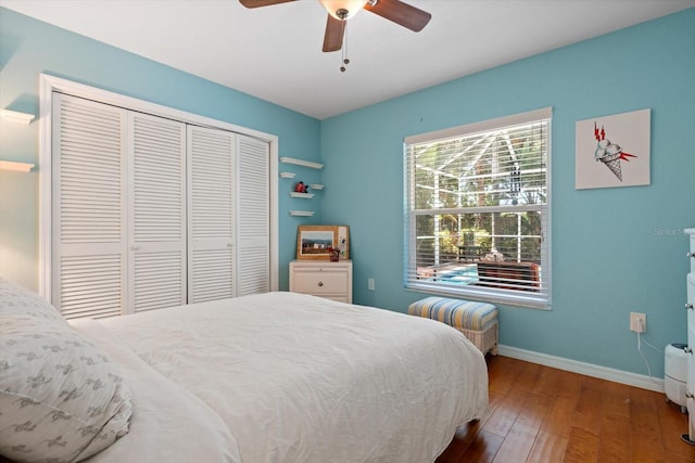 bedroom featuring a ceiling fan, a closet, baseboards, and wood finished floors