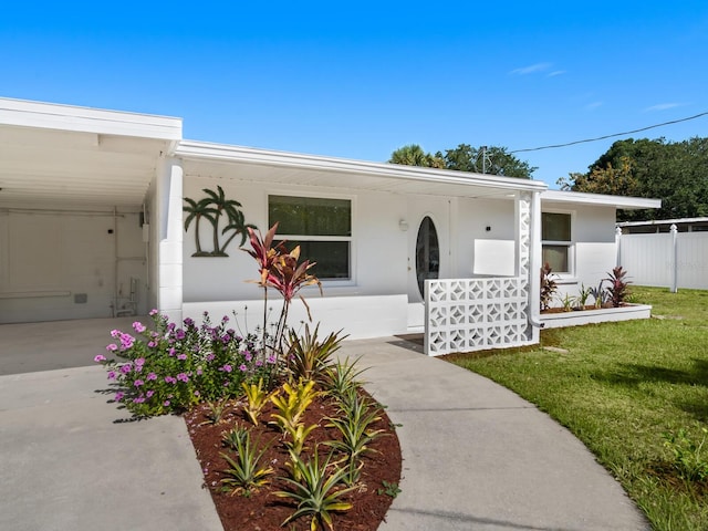 view of front facade featuring a front yard and a carport