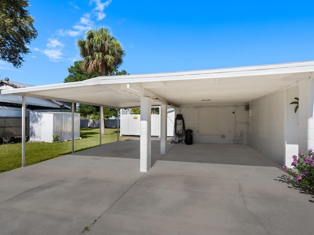 view of parking / parking lot featuring a lawn and a carport