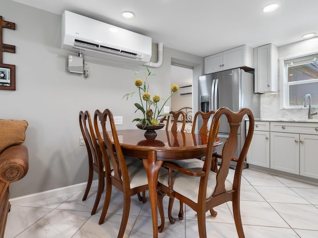 dining area with an AC wall unit and sink