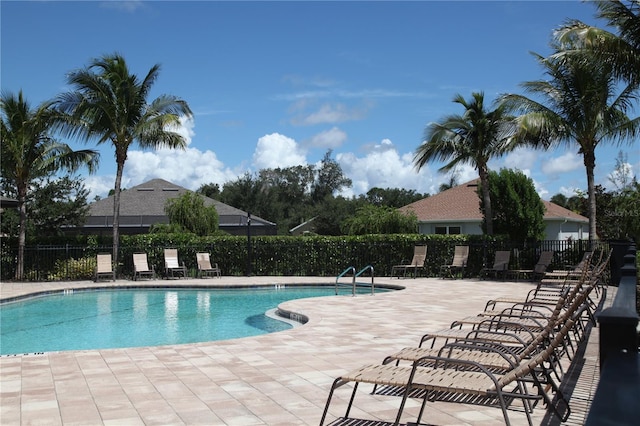 community pool featuring fence and a patio area