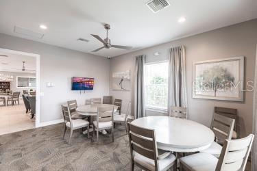 dining room with ceiling fan and dark tile patterned floors