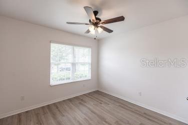 empty room with ceiling fan and hardwood / wood-style floors