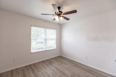 unfurnished room with baseboards, ceiling fan, and wood finished floors