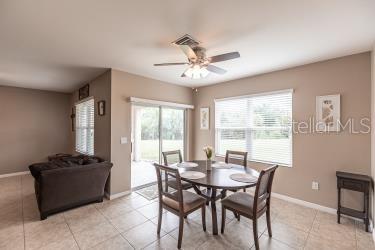 tiled dining space featuring ceiling fan