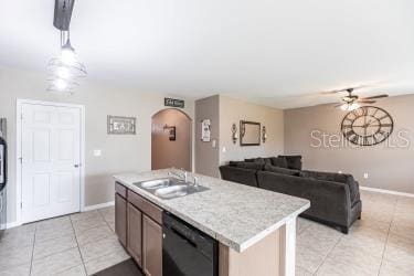kitchen featuring light countertops, black dishwasher, a ceiling fan, arched walkways, and a sink