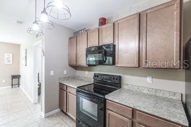 kitchen with baseboards, black appliances, light countertops, and light tile patterned floors