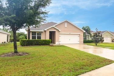 ranch-style house featuring a front yard, driveway, stucco siding, and an attached garage