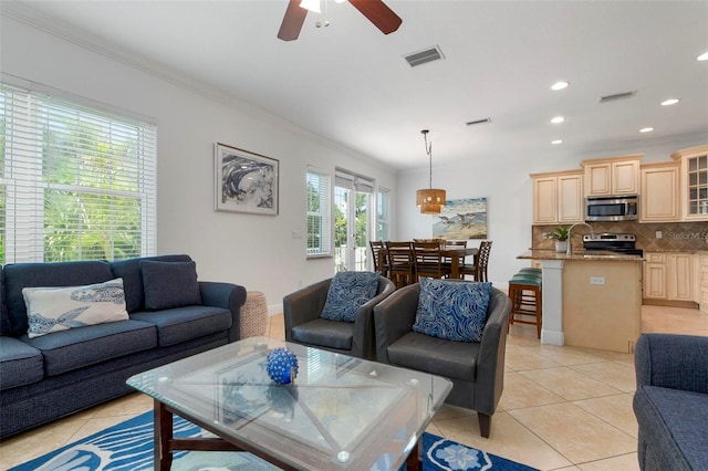 living room featuring ceiling fan, light tile patterned flooring, and ornamental molding