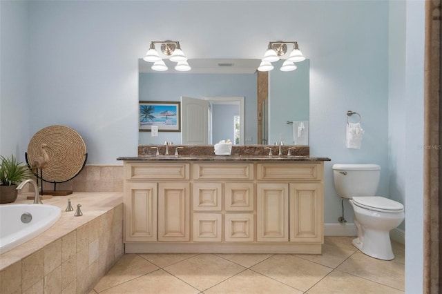 bathroom with a bath, double vanity, a sink, tile patterned flooring, and toilet