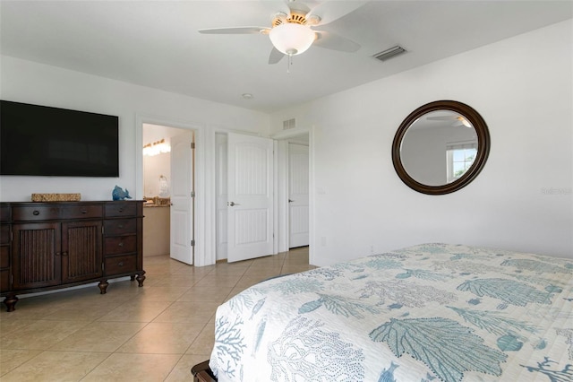 bedroom with light tile patterned floors, visible vents, connected bathroom, and ceiling fan