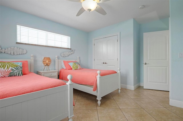 bedroom featuring ceiling fan, light tile patterned floors, and a closet