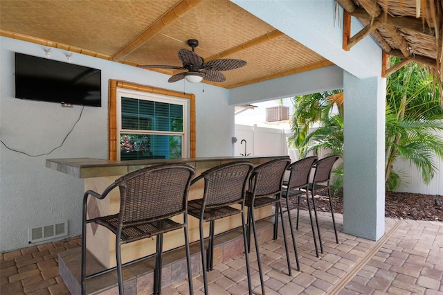 view of patio / terrace with fence, visible vents, exterior bar, and ceiling fan