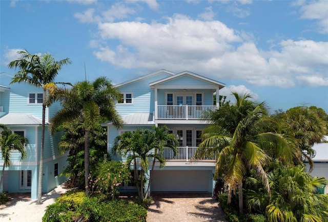 beach home with a balcony, a garage, and french doors