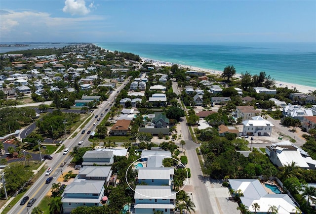 birds eye view of property with a water view and a beach view