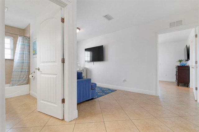 unfurnished living room featuring light tile patterned floors, baseboards, and visible vents