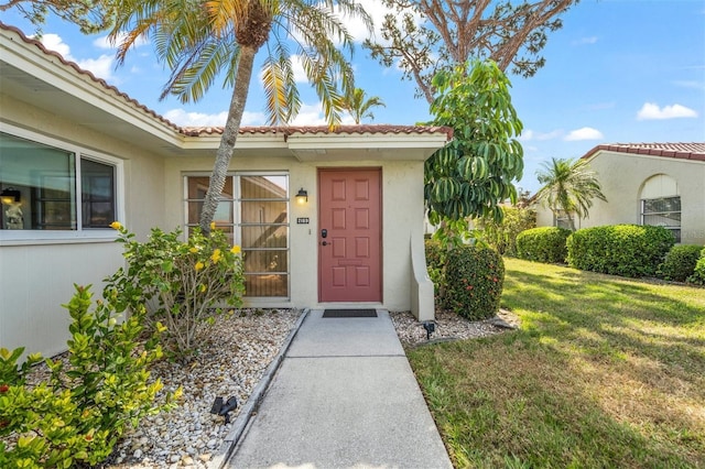 view of exterior entry with a yard