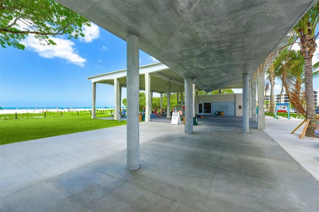 view of patio featuring a water view and a beach view