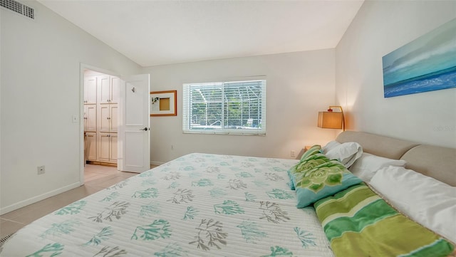 bedroom featuring light tile patterned flooring, a closet, and vaulted ceiling