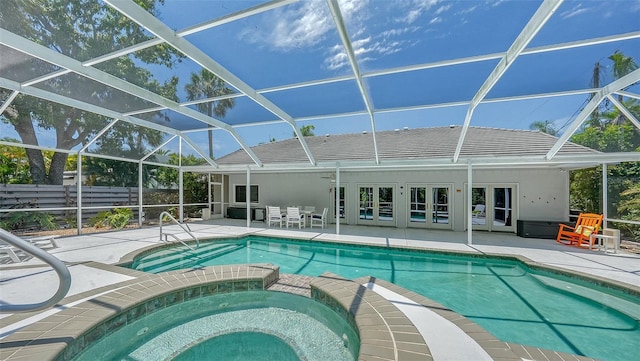 view of pool with glass enclosure, an in ground hot tub, french doors, and a patio