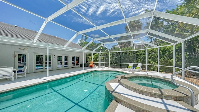 view of swimming pool with ceiling fan, french doors, a lanai, a patio area, and an in ground hot tub