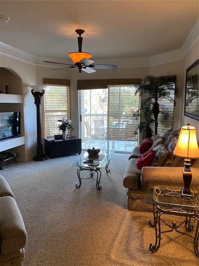 living room with ceiling fan, crown molding, and carpet