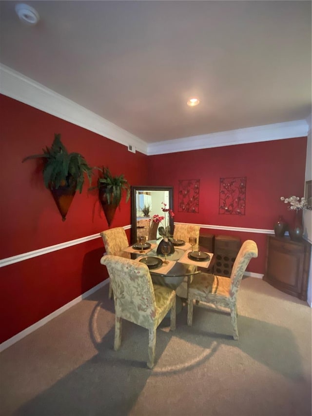 dining space featuring crown molding and carpet