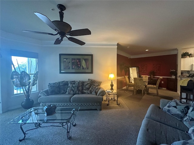 living room with ceiling fan, ornamental molding, and carpet