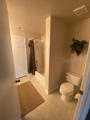 bathroom with toilet, tile patterned floors, and a shower with shower curtain