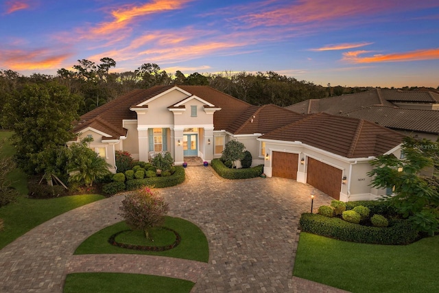 mediterranean / spanish home featuring a lawn and a garage