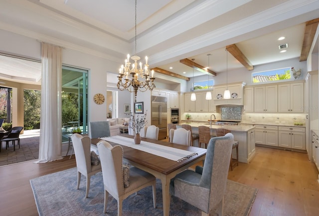 dining room with a tray ceiling, plenty of natural light, light hardwood / wood-style floors, and an inviting chandelier