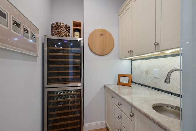 interior space with backsplash, vanity, and beverage cooler