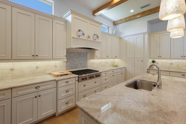 kitchen with backsplash, sink, decorative light fixtures, beam ceiling, and stainless steel gas cooktop