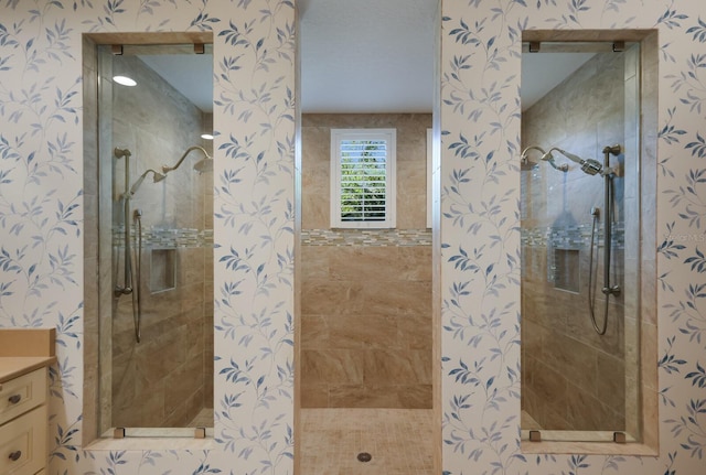 bathroom featuring a tile shower and vanity