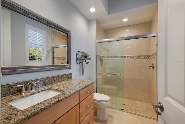 bathroom featuring tile patterned floors, vanity, toilet, and a shower with shower door