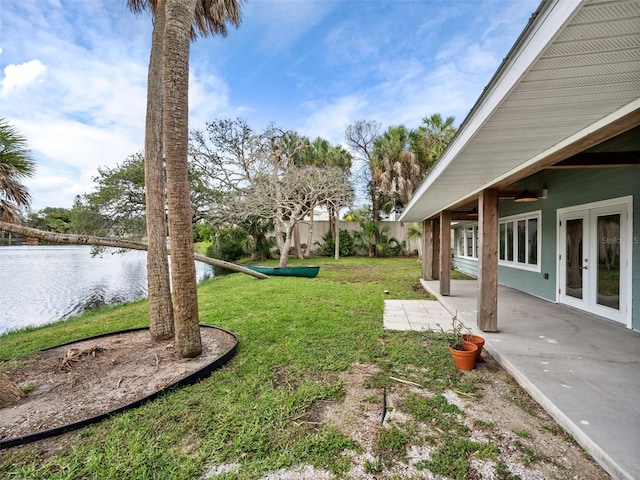 view of yard featuring a patio area, a water view, and ceiling fan