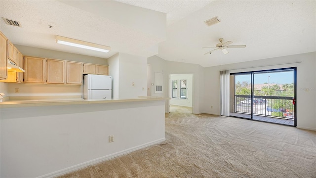 kitchen featuring light brown cabinets, lofted ceiling, a textured ceiling, light colored carpet, and white refrigerator