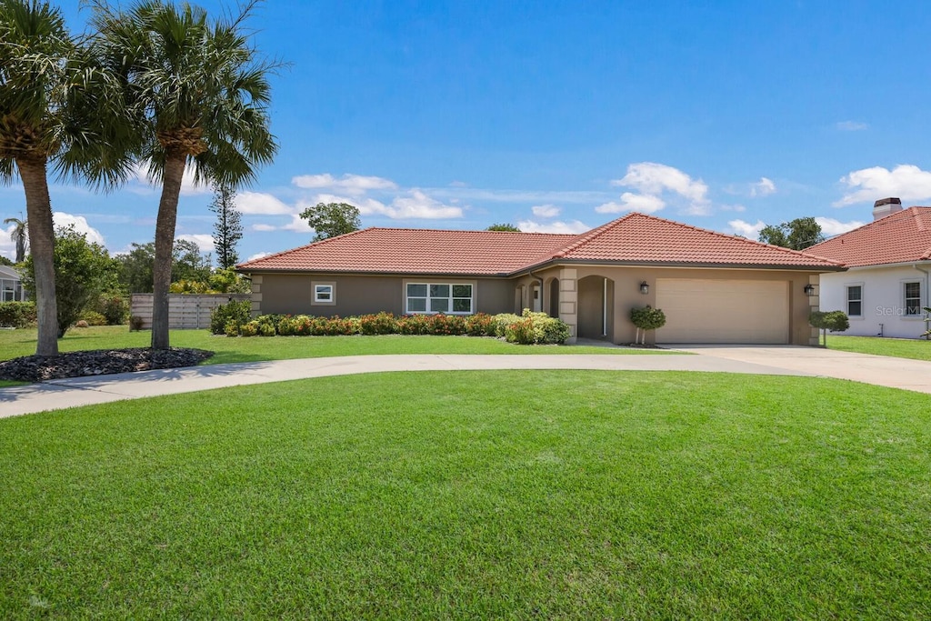 mediterranean / spanish-style house featuring a front yard and a garage