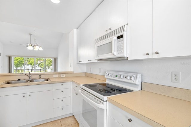 kitchen featuring white appliances, white cabinetry, vaulted ceiling, and sink