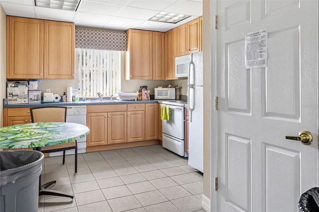 kitchen with light tile patterned floors, white appliances, a paneled ceiling, and sink